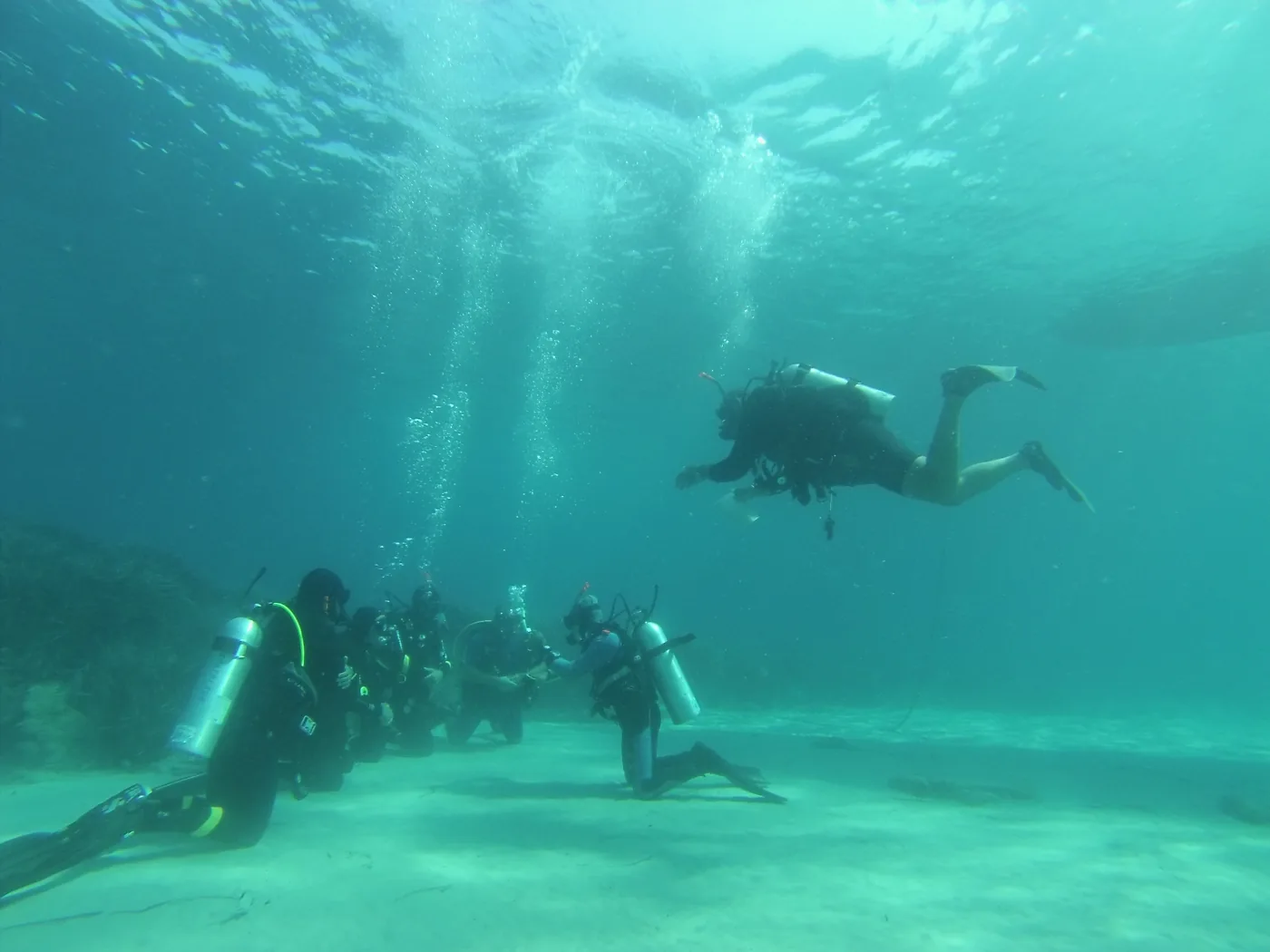 Divers practising open water skills near the seabed
