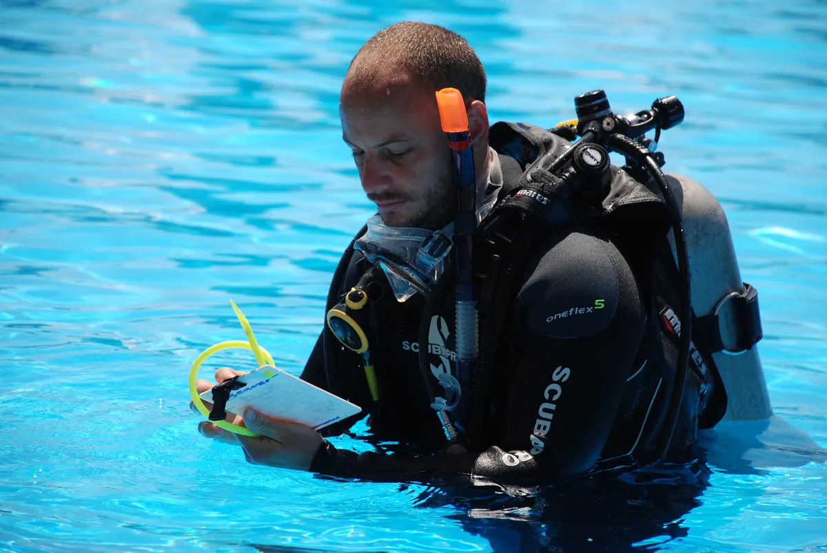 A diver using a training slate in the pool